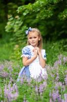 retrato de una niña linda vestida como alice. sesión de fotos estilizada en la naturaleza.