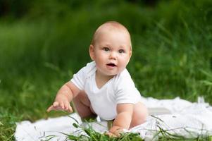 Portrait of a little cute boy in a park on nature. Shot surrounded by greenery. photo