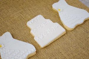cookies in the shape of a wedding dress and cake photo