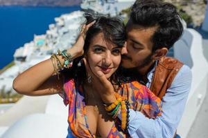 A man and a woman are hugging against the backdrop of Skaros Rock on Santorini Island. The village of Imerovigli. photo