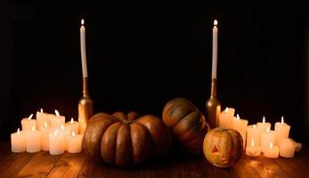 calabaza de halloween en el fondo de velas y un fondo negro. foto