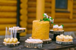 cakes on a wooden table for a wedding candy bar