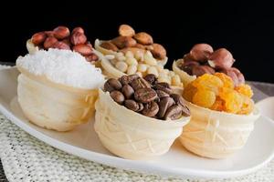 waffle basket with coffee beans, coconut, raisins, almonds, peanuts, hazelnuts and pine nuts photo