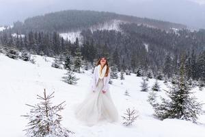 The groom leads his bride by the hand to a lonely old beech. Winter wedding. Place for a logo. photo