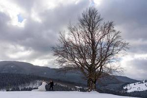 The groom leads his bride by the hand to a lonely old beech. Winter wedding. Place for a logo. photo