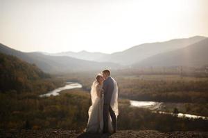 Wedding photo session of the bride and groom in the mountains. Photoshoot at sunset.