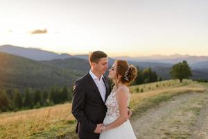 Wedding photography in the mountains. The bride and groom hug tightly. photo