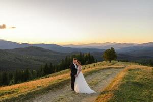 Wedding photography in the mountains. The bride and groom hug tightly. photo