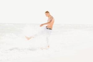 un hombre caminando por la orilla del mar foto