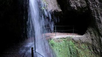 Amazing waterfall deep inside of the mountain. Tunnel, cave passage for hikers. Jungle feeling. Travel the world. Holidays for relaxing times. Levada do Moinho to Levada Nova in Madeira, Portugal. video