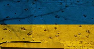 Ukrainian flag with bullet holes on the facade of a residential building as a background. Flag of Ukraine. Stop the war. Armed conflicts. Defund the armies. No to war.