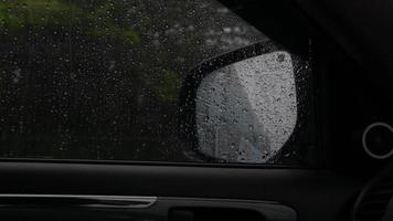 el resumen y el movimiento dentro del automóvil con una gota de lluvia golpean el espejo lateral del automóvil. video