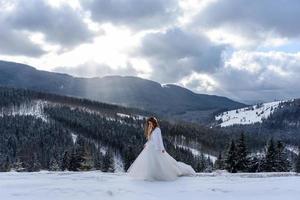 The groom leads his bride by the hand to a lonely old beech. Winter wedding. Place for a logo. photo