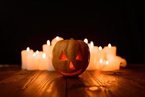 Halloween pumpkin on the background of candles and a black background. photo