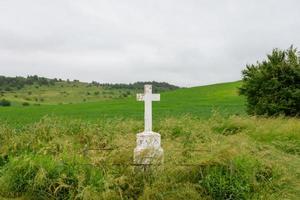 Christian cross on a background of green field. photo