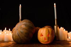 Halloween pumpkin on the background of candles and a black background. photo