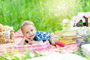 Little cute boy lies on a plaid on his stomach, resting on the elbows of his hands. The boy is looking into the frame. Place for a logo. photo