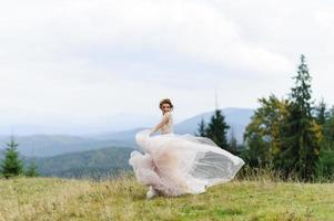 The bride in a pink airy dress swirls and plays with her dress. photo