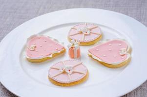 muchas galletas rosas en un plato blanco foto