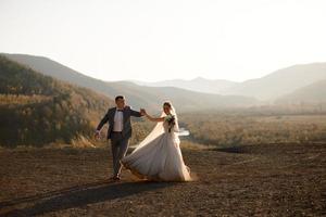 Wedding photo session of the bride and groom in the mountains. Photoshoot at sunset.