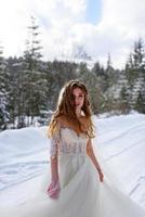 The groom leads his bride by the hand to a lonely old beech. Winter wedding. Place for a logo. photo