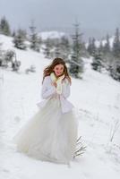 The groom leads his bride by the hand to a lonely old beech. Winter wedding. Place for a logo. photo