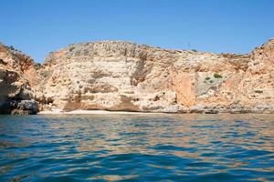 llegada en barco a una hermosa playa vacía en algarve, portugal. impresionantes acantilados de arenisca. foto