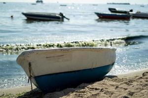 Single boat on sand with sea between circle fecne and beach view with other photo