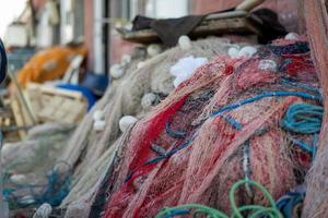 Stacked fishing nets and ropes red, green, blue and white photo