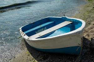 Single boat on sand with sea between circle fecne and beach view with other photo