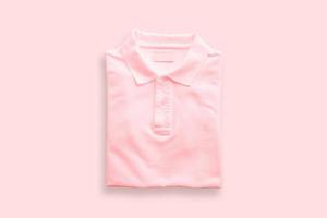 Top view of pink polo t-shirt on pink floor background. photo