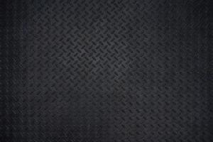 Close-up photos of Black metal floor plate texture details background. Dark wall and copy space.