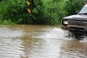 camioneta y vehículo en aguas de inundación, seguro de automóvil y concepto de situación peligrosa. foto