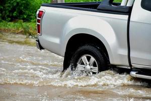 camioneta y vehículo en aguas de inundación, seguro de automóvil y concepto de situación peligrosa. foto