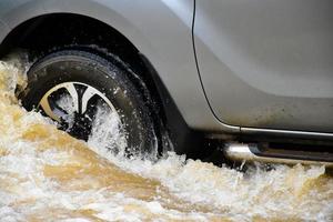 camioneta y vehículo en aguas de inundación, seguro de automóvil y concepto de situación peligrosa. foto