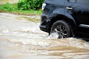 camioneta y vehículo en aguas de inundación, seguro de automóvil y concepto de situación peligrosa. foto