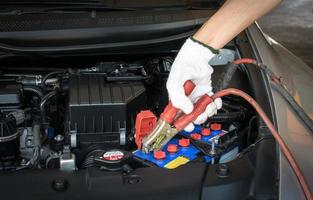 automotive technician charging vehicle battery photo