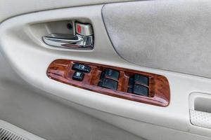 car interior details of door handle with windows controls and adjustments photo