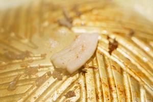 Meat being grilled on a brass pan photo