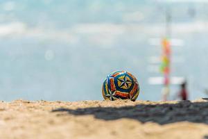 The ball rests on the sand on the beach. photo