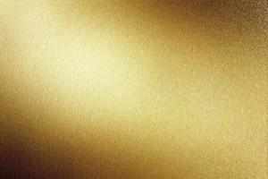 Light shining on brushed gold metal plate, abstract texture background photo