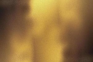 Brushed bronze foil metallic wall with glowing shiny light, abstract texture background photo