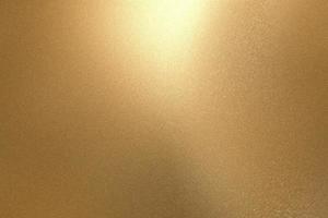 Light shining on rough gold metallic wall surfaces, abstract texture background photo