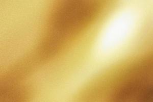 Light shining on gold painted metal sheet with copy space, abstract texture background photo