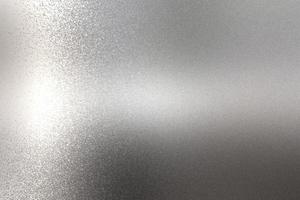 Light shining on rough chrome metal wall texture, abstract background photo