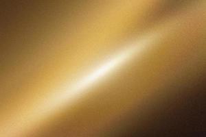 Light shining down on dark gold foil metal wall with copy space, abstract texture background photo