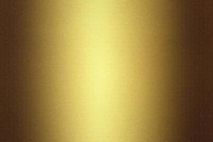 Light shining on golden metallic plate in dark room, abstract texture background photo