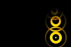 Abstract yellow sound waves oscillating with circle ring on black background photo