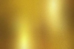 Gold foil metallic wall with glowing shiny light, abstract texture background photo