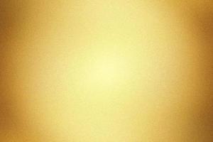 Glowing gold painted metal wall with copy space, abstract texture background photo